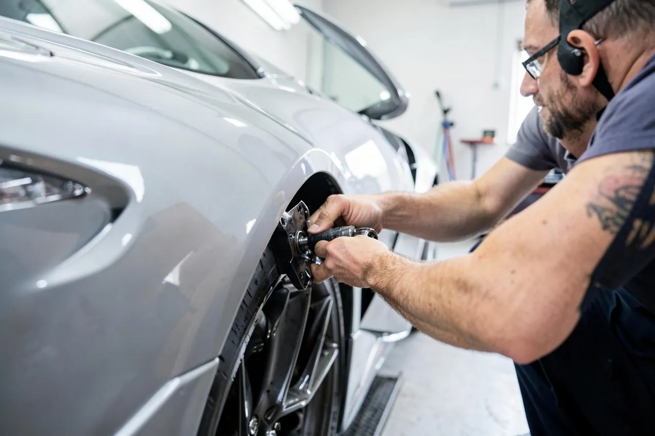 Monteur past een body kit onderdeel op een auto in de werkplaats